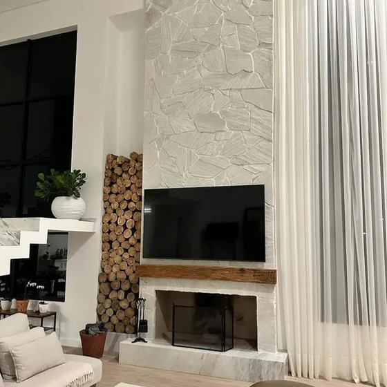 Sala com lareira e revestimento em pedra clara