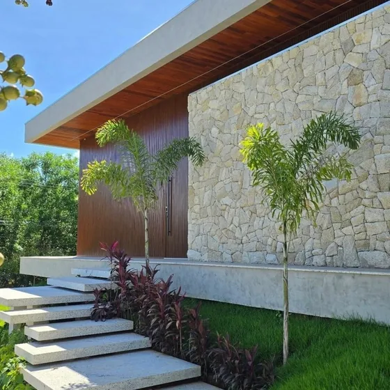 Fachada em pedra natural com escada e paisagismo